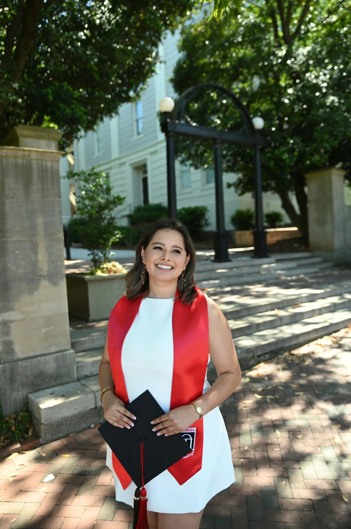 Anna Medina in graduation attire outside the University of Georgia